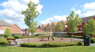 A children's play area with swings and a climbing frame